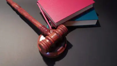 gavel and sounding block on desk next to books