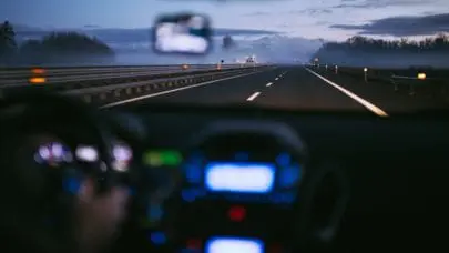 Photo from the inside of a car looking out onto the expanse of road ahead. Drivers should be wary of road debris hazards and understand liability in cases of damage or accidents.